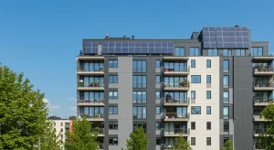 Ayudas Estatales 2026: Rehabilitación de Viviendas con 40% Subvención Fachada moderna de edificio residencial rehabilitado con paneles solares, simbolizando las ayudas estatales 2026 para viviendas.