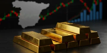 Barras de oro y plata apiladas, reflejando gráficos económicos y el mapa de España, simbolizando inversión en 2026.