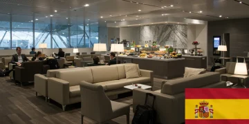 Interior de un lounge premium de aeropuerto moderno con viajeros relajados y servicios de lujo.